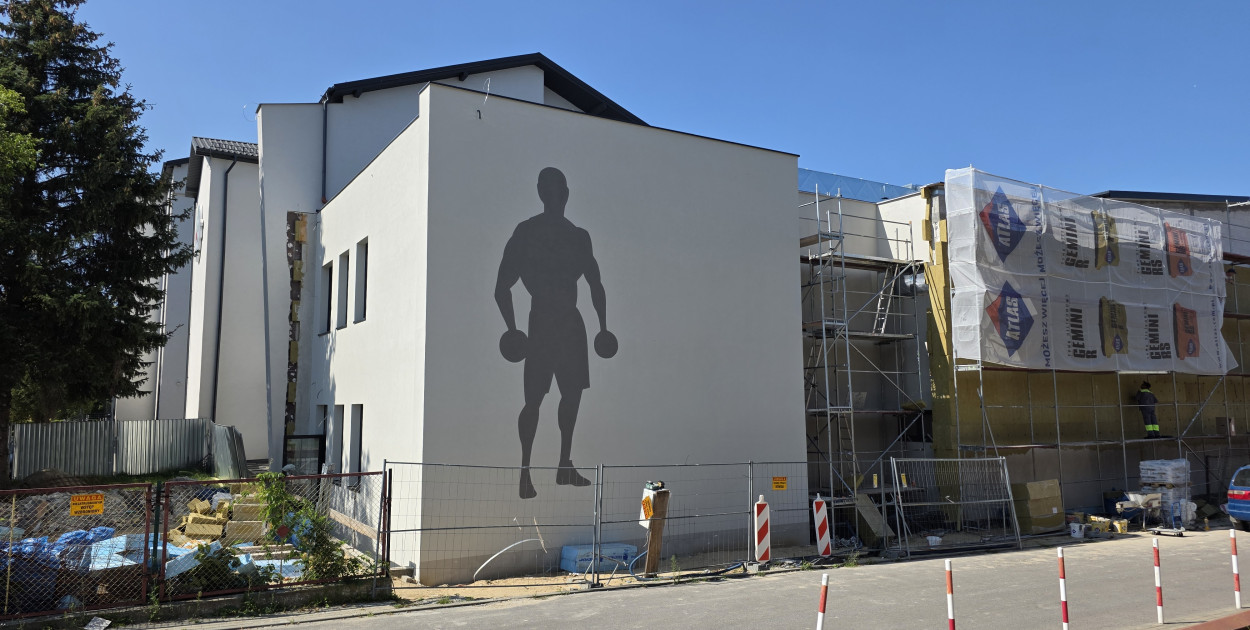 Biłgorajanka Faustyna Kaczor maluje mural na nowej hali sportowej przy RCEZ